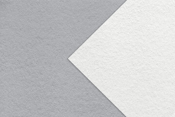 Texture of gray paper background, half two colors with white arrow, macro. Structure of craft grey cardboard.