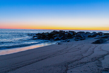 Blue hour on the beach with rocks in the water, long exposure