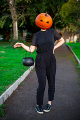 Halloween themed woman in black with a pumpkin on her head