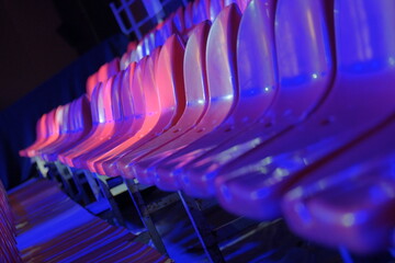 red plastic grandstand chairs under blue light