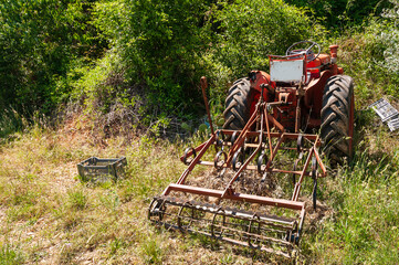 Agricultural equipment and a tractor, in a field in spring