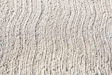 New concrete roadbed background made with cement and stone gravel with a striped finish