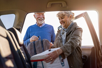 Senior couple packing a car

