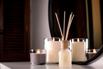 Air freshener in a glass bottle and scented candles in candle holders. Home atmosphere. Fragrances...