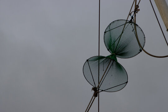 Close up of fishing net hanging in the rigging of a fish trawler