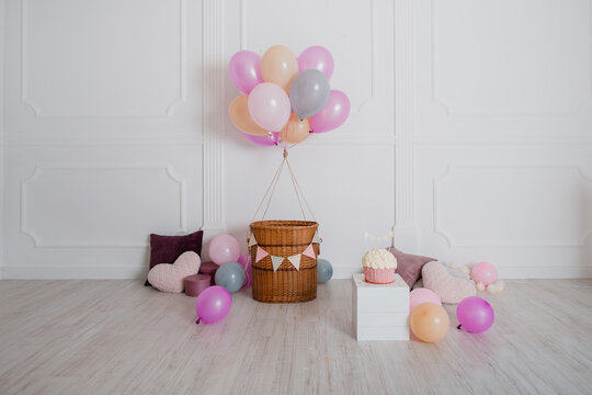Fotozone f&uuml;r einen Kindergeburtstag in hellen, pastellfarbenen Blumen mit Luftballon, B&auml;llen, Kuchen