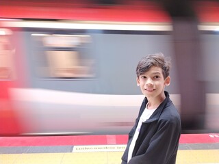 boy posing while passing the subway