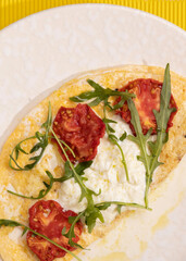 amlet with egg and greens on a white plate on a yellow background
