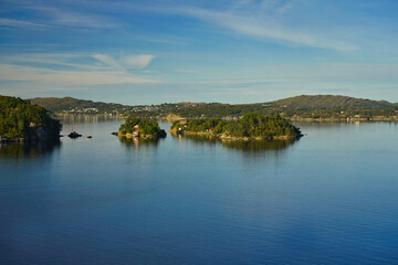 Fototapeta na wymiar Bewohnte Inseln vor der Küste Süd-Norwegens auf der Schiffspassage nach Bergen 