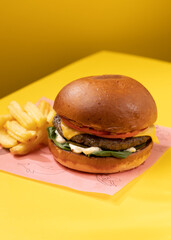 burger with french fries on a yellow background