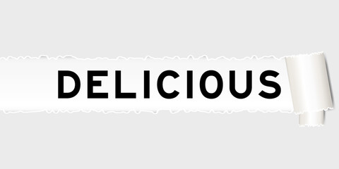 Ripped gray paper background that have word delicious under torn part