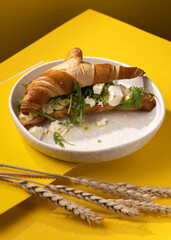 croissant with egg on a yellow background