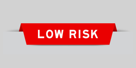 Red color inserted label with word low risk on gray background