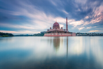 Beautiful sunrise At Putra Mosque, Putrajaya Malaysia with colorful clouds and reflection on the lake surface.