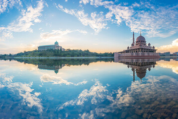 Beautiful sunrise At Putra Mosque, Putrajaya Malaysia with colorful clouds and reflection on the lake surface.