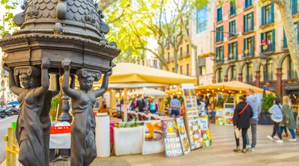 Foto auf Leinwand La Rambla most popular pedestrian street in Barcelona. Selective focus on drinking water fountain on foreground. © Arcady