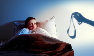 Little boy in a bedd scared of punishment