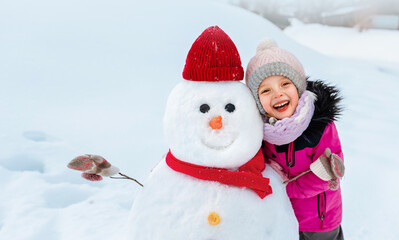 The child made a big snowman and decorated it with a wide smile and clothe