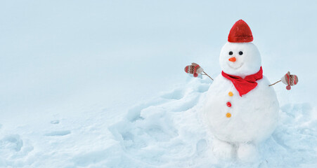 Cute cheerful snowman who smiles broadly, decorated in a warm knitted hat and scarf with mittens