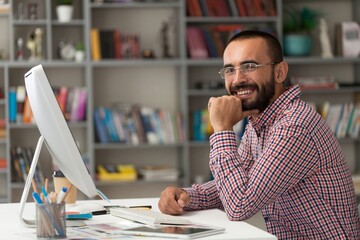 Bearded businessman working on computer in office. Video online webinar.