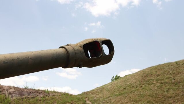 The green muzzle of a tank against the blue sky. The concept of military conflicts and children, war. Copy space for text