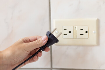 Hand holding power cable which doesnt feet to the electrical plug type B.