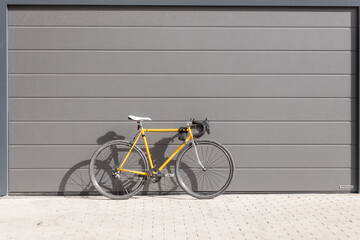vintage yellow racing bike leaning against a gray wall