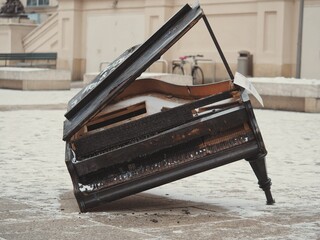 Broken piano standing on only one leg captured outdoors © Adsw/Wirestock Creators