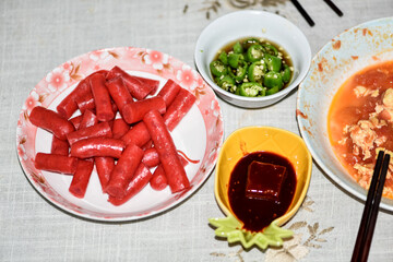 Lunch of traditional Chinese food sausage, rolls, chili, pomegranate, soy bean curd