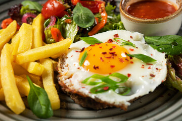 Hearty breakfast with fried eggs, french fries
