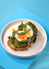 toast with egg and greens on a blue background