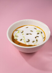 pumpkin cream soup on a pink background