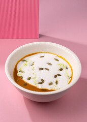 pumpkin cream soup on a pink background
