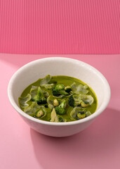 cream broccoli soup on a pink background