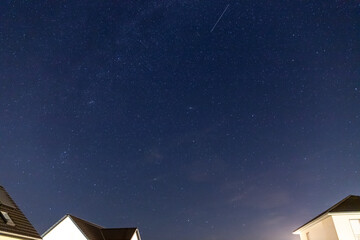 Starry sky over a housing settlement with meteorites (Perseids in August)