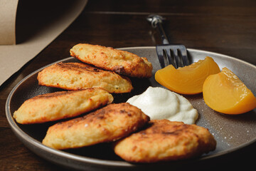 Cottage cheese pancakes,curd fritters with  and apricot slices  and sour cream in a dish. Gourmet Breakfast
