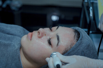 Modern facial skin rejuvenation procedures using cold cryotherapy in a beauty salon.