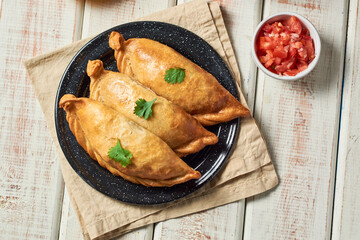 Latin American fried stuffed empanadas wooden table