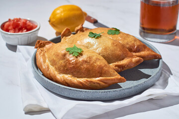 Latin American fried stuffed empanadas on a white marble background