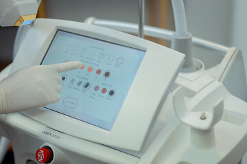 Doctor's hand with device HydraFacial facial skin care machine in spa clinic for anti-aging or acne treatment. The concept of aesthetic medicine, beauty tools, latest technologies in beauty industry