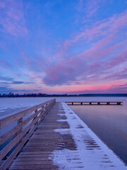 Obraz na płótnie Canvas Pier on a frozen lake. Sunset over a frozen lake.