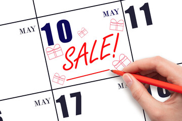 Hand writing text SALE and drawing gift boxes on calendar date May 10. Shopping Reminder