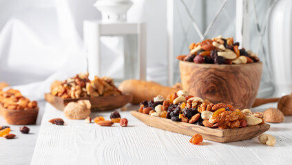 Mix of nuts and raisins on a white wooden table.