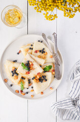 Pancakes with blueberries, peach and mint on a plate. White wooden table. Light background. Serving a rustic table with yellow flowers and a yellow drink