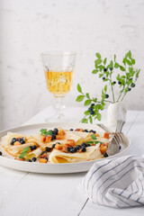 Pancakes with blueberries, peach and mint on a plate. White wooden table. Light background. Serving a rustic table with yellow flowers and a yellow drink