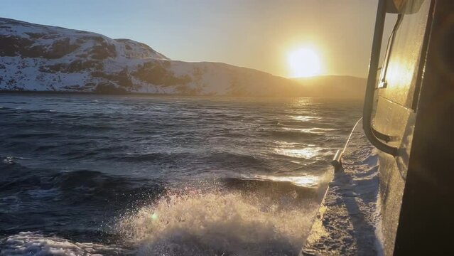 Waves from a sailing yacht in the sun. Beautiful sea sunset. Water splashes from a boat. The boat on the motor floats on the river.