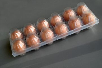 Boîte à œufs en plastique en gros plan sur fond gris