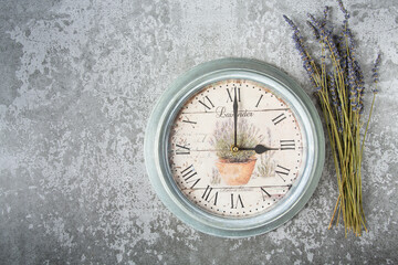 Beautiful vintage clock with lavender flowers on grey stone surface