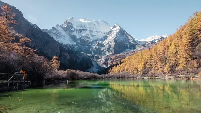 Xiannairi holy mountain with emerald lake in autumn pine forest on sunny day at Yading nature reserve