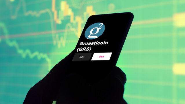 September 13th 2022, London UK. An investor's analyzing the Groestlcoin (GRS) coin on screen. A phone shows the crypto's prices to invest